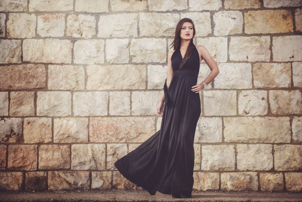 model in rochie neagra langa zid de caramida